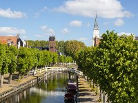 Canal in historic Dutch  town Sloten, Friesland  Canal in historic Dutch  town Sloten, Friesland : sleat, sloten, friesland, de friese meren, Europe, european, fryslan, Holland, Netherlands, blue, canal, coud, espalier, frisian, green, historic, history, in a row, many, road, row, sky, street, the way to go, town, tree, trees, urban landscape, urban scene, water, white clouds, bridge, tower