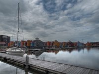 A sailing boat  A sailing boat in front of a residential area : Netherlands, architecture, architectuur, blauw, blue, boat, boats, bollard, boot, boten, building, buildings, colorful, colors, dorkwerd, gebouw, gebouwen, geel, gray, grijs, groningen, harbour, haven, holland, home, house, houses, housing, huis, huisvesting, huizen, jachthaven, jetty, kleuren, kleurrijk, landscape, marina, nederland, orange, oranje, paal, reitdiep, reitdiephaven, residential, rudmer zwerver, schepen, schip, ship, steiger, suburb, thuis, vinex, voorstad, water district, waterfront living, waterwijk, wonen aan het water wonen, woningen, yellow, zeilboot, zeilschip