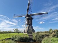Historic windmill Doris Mooltsje, Oudega, Sudwest-Fryslan, Friesland, Netherlands  Historic windmill Doris Mooltsje, Oudega, Sudwest-Fryslan, Friesland, Netherlands : windmill, Doris Mooltsje, Oudega, Aldegea, Sudwest-Fryslan, Friesland, Netherlands, Dutch, europe, european, building, architecture, monument, historic, history, culture, dutch culture, travel destination, destination, black, 4, four, wings, rural, landscape, rural landscape, outside, outdoor, outdoors, no people, nobody, season, summer, summertime, sky, blue sky, white clouds, grass, ditch, water