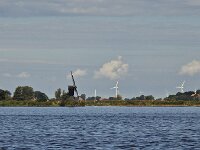 Bank of Dutch lake Aldegeaster Brekken with historic windmill Doris Mooltsje, Oudega, Sudwest-Fryslan, Friesland, Netherlands  Bank of Dutch lake Aldegeaster Brekken with historic windmill Doris Mooltsje, Oudega, Sudwest-Fryslan, Friesland, Netherlands : windmill, Doris Mooltsje, Oudega, Aldegea, Sudwest-Fryslan, Friesland, Netherlands, Dutch, europe, european, building, architecture, monument, historic, history, culture, dutch culture, travel destination, destination, black, wings, rural, landscape, rural landscape, outside, outdoor, outdoors, no people, nobody, season, summer, summertime, bank, horizon